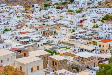 Lindos, Yunanistan, 25 Ağustos 2022: Rodos adasındaki Lindos kasabasındaki beyaz evlerin panorama manzarası.