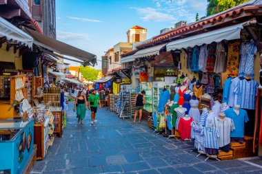 Rodos, Yunanistan, 26 Ağustos 2022: Yunan kenti Rodos 'ta bir turist caddesinin gün batımı manzarası.