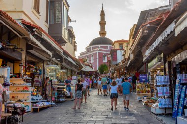 Rodos, Yunanistan, 26 Ağustos 2022: Girit adasındaki Yunan limanı Rodos 'taki Süleyman Camii' ne giden bir turist caddesinin gün batımı manzarası.