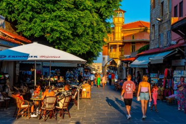 Rodos, Yunanistan, 26 Ağustos 2022: Yunan kenti Rodos 'ta bir turist caddesinin gün batımı manzarası.
