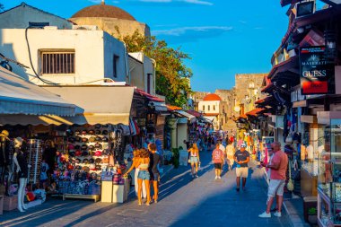 Rodos, Yunanistan, 26 Ağustos 2022: Yunan kenti Rodos 'ta bir turist caddesinin gün batımı manzarası.
