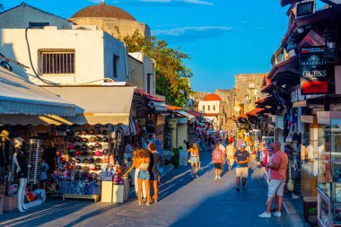 Rodos, Yunanistan, 26 Ağustos 2022: Yunan kenti Rodos 'ta bir turist caddesinin gün batımı manzarası.