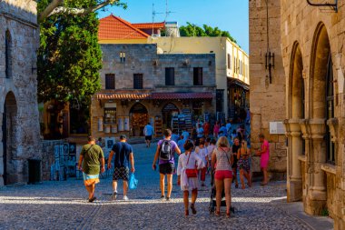 Rodos, Yunanistan, 27 Ağustos 2022: Yunan kenti Rodos 'ta bir turist caddesinin gün batımı manzarası.