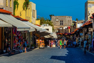 Rodos, Yunanistan, 27 Ağustos 2022: Yunan kenti Rodos 'ta bir turist caddesinin gün batımı manzarası.