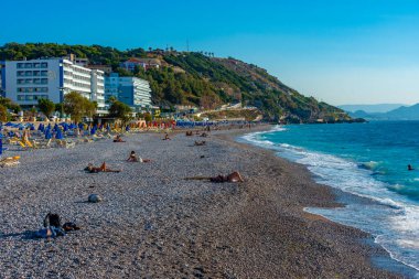 Rodos, Yunanistan, 27 Ağustos 2022: Yunanistan 'ın Rodos kentinde bir plajda güneşlik ve şemsiyeler.