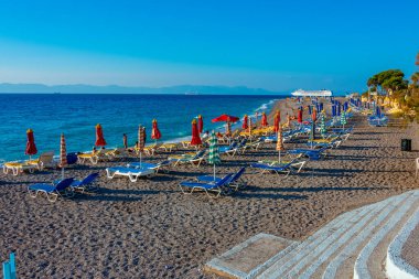 Rodos, Yunanistan, 27 Ağustos 2022: Yunanistan 'ın Rodos kentinde bir plajda güneşlik ve şemsiyeler.