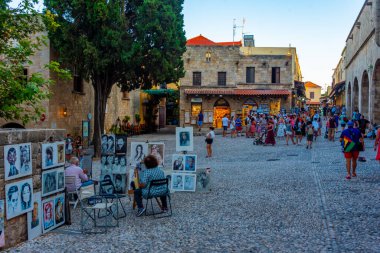 Rodos, Yunanistan, 27 Ağustos 2022: Yunan kenti Rodos 'ta bir turist caddesinin gün batımı manzarası.