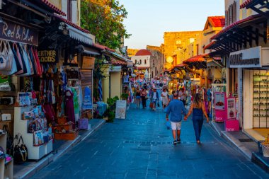 Rodos, Yunanistan, 27 Ağustos 2022: Yunan kenti Rodos 'ta bir turist caddesinin gün batımı manzarası.