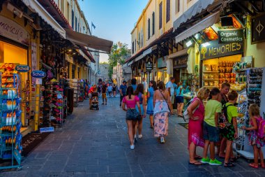 Rodos, Yunanistan, 27 Ağustos 2022: Yunan kenti Rodos 'ta bir turist caddesinin gün batımı manzarası.