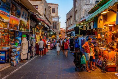 Rodos, Yunanistan, 27 Ağustos 2022: Yunan kenti Rodos 'ta bir turist caddesinin gün batımı manzarası.