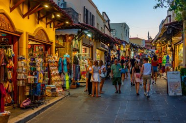 Rodos, Yunanistan, 27 Ağustos 2022: Yunan kenti Rodos 'ta bir turist caddesinin gün batımı manzarası.