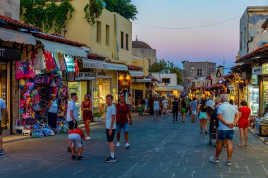 Rodos, Yunanistan, 27 Ağustos 2022: Yunan kenti Rodos 'ta bir turist caddesinin gün batımı manzarası.