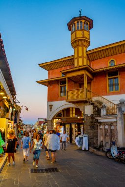 Rodos, Yunanistan, 27 Ağustos 2022: Yunan kenti Rodos 'ta bir turist caddesinin gün batımı manzarası.