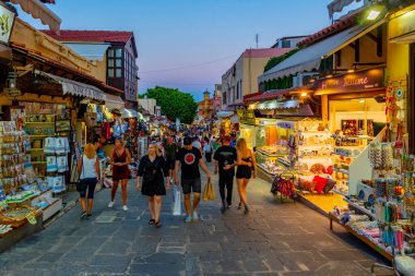 Rodos, Yunanistan, 27 Ağustos 2022: Yunan kenti Rodos 'ta bir turist caddesinin gün batımı manzarası.