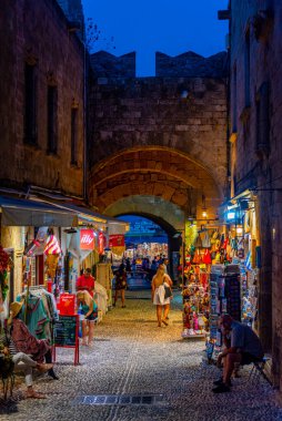 Rodos, Yunanistan, 27 Ağustos 2022: Yunan kenti Rodos 'ta bir turist caddesinin gün batımı manzarası.