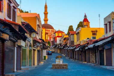 Rodos, Yunanistan, 28 Ağustos 2022: Girit adasındaki Yunan limanı Rodos 'taki Süleyman Camii' ne giden bir turistik caddenin gün doğumu manzarası.