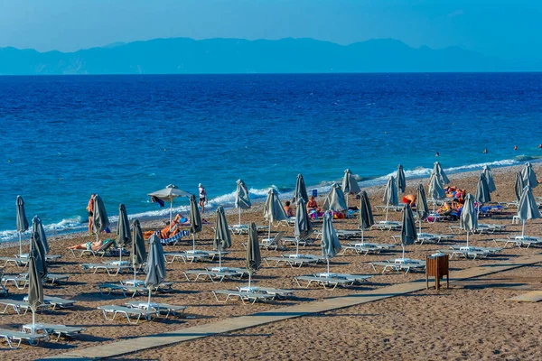 stock image Rhodes, Greece, August 27, 2022: Sunbeds and umbrellas at a beach in Rhodes town in Greece.