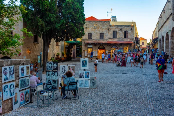 Rodos, Yunanistan, 27 Ağustos 2022: Yunan kenti Rodos 'ta bir turist caddesinin gün batımı manzarası.