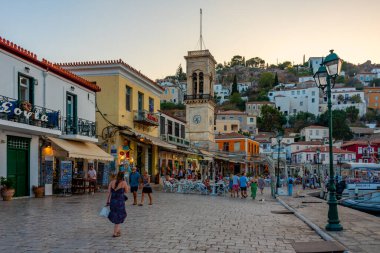 Hydra, Yunanistan, 4 Eylül 2022: Yunanistan 'ın Hydra limanındaki deniz kenarındaki gezinti alanının gün batımı manzarası.