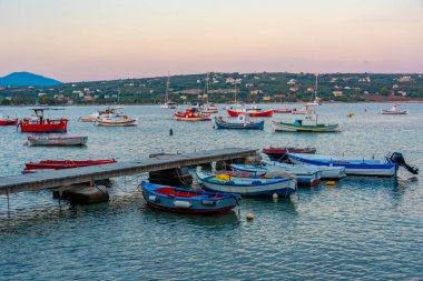 Methoni, Yunanistan, 7 Eylül 2022: Yunanistan 'daki Methoni şatosunun yanında demirleyen teknelerin günbatımı manzarası.