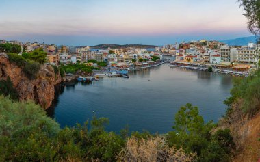 Agios Nikolaos, Yunanistan, 19 Ağustos 2022: Voulismeni gölü ve Yunan kenti Agios Nikolaos 'un Girit adasındaki günbatımı manzarası.