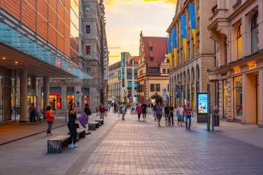 Leipzig, Almanya, 8 Ağustos 2022: Alman kenti Leipzig 'deki ticari bir caddenin gün batımı manzarası.