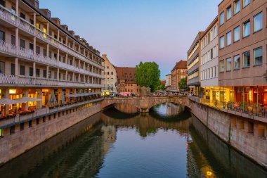 Nurnberg, Almanya, 9 Ağustos 2022: Nurnberg, Almanya 'daki Paskalya pazarına doğru müze şemsiyesi üzerinde yürüyen insanların günbatımı..