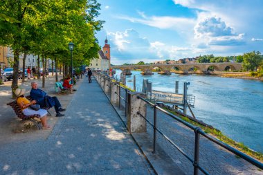 Regensburg, Almanya, 12 Ağustos 2022: Almanya 'nın Regensburg kentinde Tuna Nehri üzerindeki eski taş köprü.