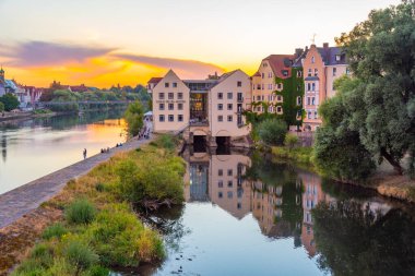 Regensburg, Almanya, 12 Ağustos 2022: Almanya 'nın Regensburg kentindeki Tuna Nehri' nin kıyısındaki renkli evler.
