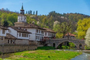 Tryavna, Bulgaristan, 24 Nisan 2022: Bulgaristan 'daki bir nehrin arkasındaki Tryavna şehir merkezindeki tarihi saat kulesi.