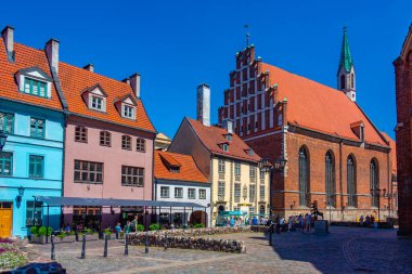 Riga, Letonya, 24 Haziran 2022: St. John Kilisesi ve Letonya 'nın Riga kentindeki renkli bir cadde..