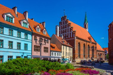 Riga, Letonya, 24 Haziran 2022: St. John Kilisesi ve Letonya 'nın Riga kentindeki renkli bir cadde..