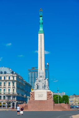 Riga, Letonya, 24 Haziran 2022: Riga, Letonya 'daki Özgürlük Anıtı' nın yanında yürüyen insanlar. .
