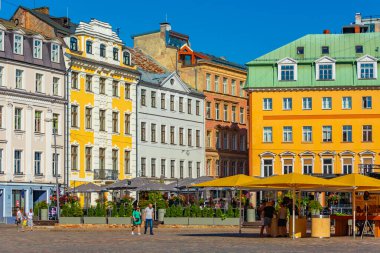Riga, Letonya, 24 Haziran 2022: Letonya 'nın başkenti Riga' daki restoranlarla dolu Doma Laukums Meydanı 'nda insanlar geziniyor..