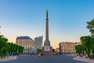 Riga, Letonya, 24 Haziran 2022: Riga, Letonya 'daki Özgürlük Anıtı' nın yanında yürüyen insanlar. .