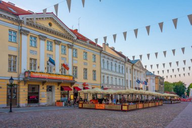 Tartu, Estonya, 27 Haziran 2022: Estonya 'nın Tartu kentindeki belediye binasındaki restoranların günbatımı manzarası.