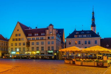 Tallinn, Estonya, 29 Haziran 2022: Estonya 'nın Tallinn kentindeki belediye binası meydanını çevreleyen restoranların gece manzarası..