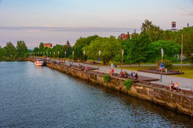 Parnu, Estonya, 1 Temmuz 2022: İnsanlar Estonya 'daki Parnu nehrinin nehir kıyısında günbatımının tadını çıkarıyorlar.