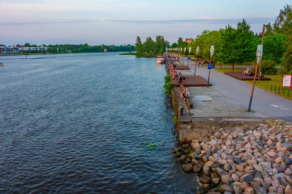Parnu, Estonya, 1 Temmuz 2022: İnsanlar Estonya 'daki Parnu nehrinin nehir kıyısında günbatımının tadını çıkarıyorlar.