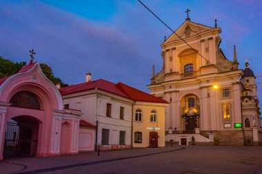 Vilnius, Litvanya, 6 Temmuz 2022: Litvanya 'nın Vilnius kentindeki St. Theresa Kilisesi' ne giden bir caddenin gece görüşü..
