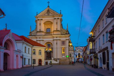 Vilnius, Litvanya, 6 Temmuz 2022: Litvanya 'nın Vilnius kentindeki St. Theresa Kilisesi' ne giden bir caddenin gece görüşü..