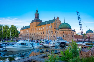 Vadstena, İsveç, 16 Temmuz 2022: İsveç 'teki marina ve Vadstena kalesinin gün batımı manzarası.