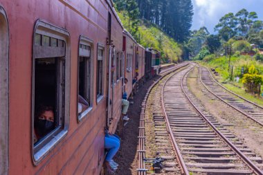 Ella, Sri Lanka, 29 Ocak 2022: Sri Lanka 'daki çay tarlaları arasında yamaçta gezinen tren.