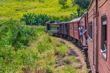 Ella, Sri Lanka, 29 Ocak 2022: Sri Lanka 'daki çay tarlaları arasında yamaçta gezinen tren.