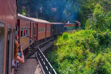 Ella, Sri Lanka, 29 Ocak 2022: Sri Lanka 'daki çay tarlaları arasında yamaçta gezinen tren.