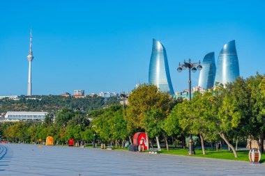 Bakü, Azerbaycan 'da arka planda Alev Kuleleri olan deniz kenarı gezinti alanı