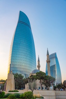 Azerbaycan 'ın Bakü kentindeki Alev Kuleleri ve Şehitler Sokağı Camii' nin gün batımı manzarası