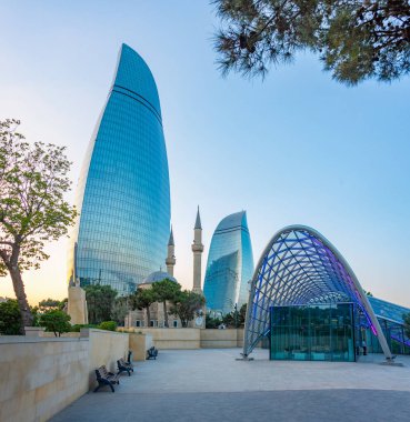 Azerbaycan 'ın Bakü kentindeki Alev Kuleleri ve Şehitler Sokağı Camii' nin gün batımı manzarası