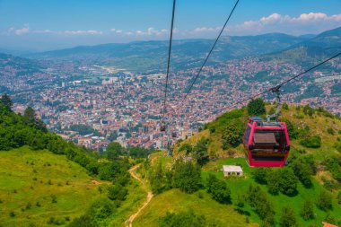 Trebevic gondola raising from the old town of Sarajevo, Bosnia and Herzegovina clipart