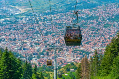 Trebevic gondola raising from the old town of Sarajevo, Bosnia and Herzegovina clipart